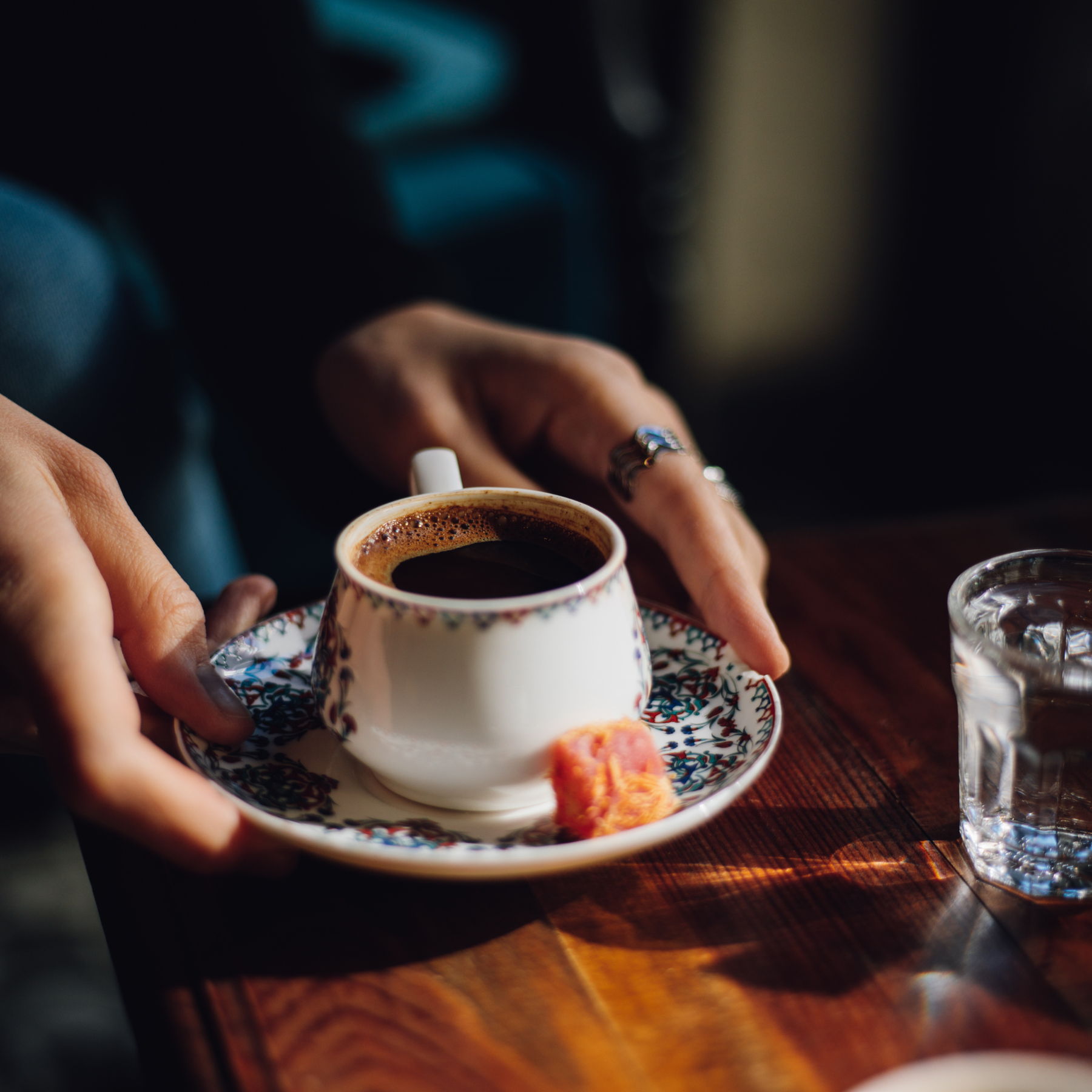 Hands cradling a glass of Turkish tea at Öze's Cafe.